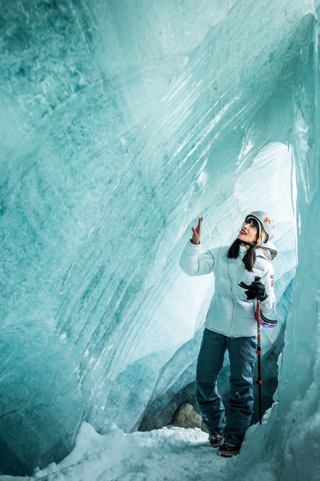 Guests step into blue‑lit ice tunnels beneath a glacier near Whistler after a heli drop, catered experience set nearby.